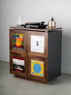 a record player sitting on top of a wooden cabinet