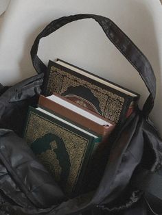 an open book bag sitting on top of a white chair next to a black purse