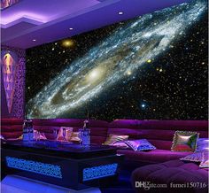 a living room filled with purple couches next to a wall covered in space and stars