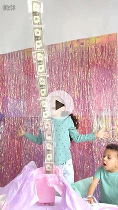 two children are standing in front of a giant clock with money on it's face