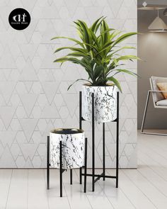 three black and white planters sitting next to each other in front of a wall