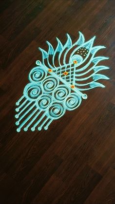 an intricately designed bird is on the floor in front of a wooden table top