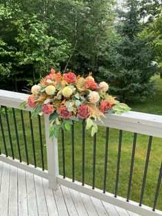 an arrangement of flowers is placed on the railing