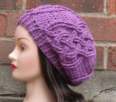 a close up of a mannequin head wearing a purple knitted beanie