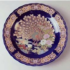 a blue and gold plate with a peacock on it