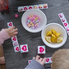 two children playing with valentine's day cards on a table