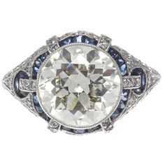 an antique diamond and blue sapphire ring with diamonds on the sides, set in white gold