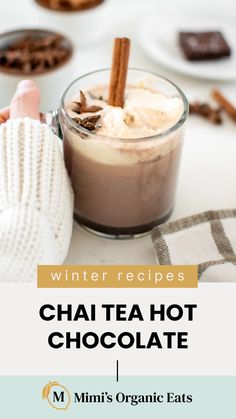 hot chocolate in a glass mug with cinnamon sticks and whipped cream