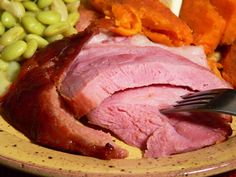 a close up of a plate of food with meat, beans and vegetables on it