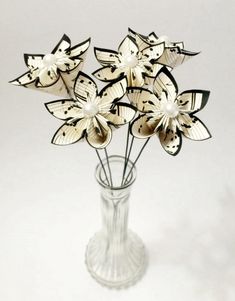 a glass vase filled with white flowers on top of a table next to a wall