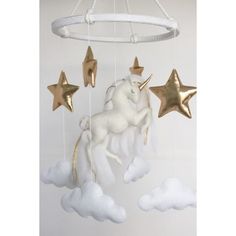 a white and gold unicorn mobile with stars hanging from it