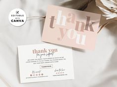 a thank you card sitting on top of a bed next to some flowers and paper