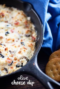 a skillet filled with cheese dip and crackers