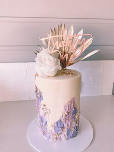 a white and purple cake with flowers on top