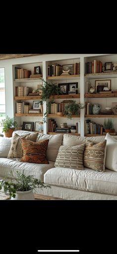 a living room filled with lots of furniture and bookshelves on top of each other