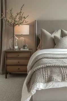 a bedroom with a bed, nightstands and two lamps on either side of the bed