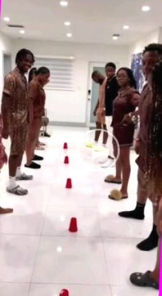 a group of people standing next to each other in front of red and white cones