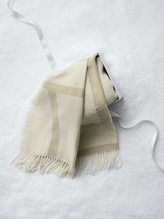 a white and beige blanket laying on top of snow