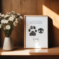 a vase filled with flowers next to a framed print that says if love could save the world, we have lived forever