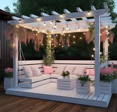 an outdoor seating area is lit up with string lights and pink flowers on the bench