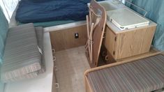 the interior of a small camper with a bed, desk and chair next to it