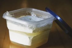 a plastic container filled with ice sitting on top of a wooden table