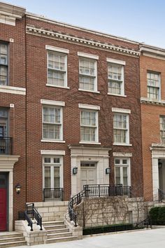 an apartment building with stairs leading up to the front door and second story doors on either side