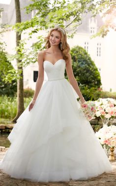 a woman in a white wedding dress is posing for the camera with her hand on her hip