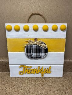 a wooden sign that says, thank you and has a plaid pumpkin on the front