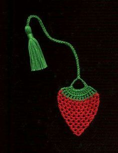 a crocheted strawberries bag with a tassel hanging from it's side