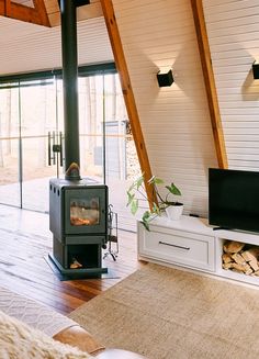 a living room filled with furniture and a fire place next to a tv on top of a wooden floor