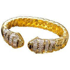 A heavy and very well made cuff bracelet done in 18K yellow gold and set with approximately 6cttw in G-I color Vs1-2 clarity baguette and round diamonds. Dimensions Bracelet measures .60” at the widest point and fits a size 7 wrist. 51.6g. Condition Some light surface scuffing. Very wearable condition. Luxury Jubilee Baguette Bracelets, Luxury Yellow Gold Bracelets With Cabochon, Luxury Elegant Baguette-cut Bracelet, Luxury Baguette-shaped Elegant Bracelet, Luxury Baguette-cut Diamond Bracelet With 17 Jewels, Cuff Bangle Bracelet, Diamond Bangle, Cuff Bangles, Cuff Bracelet