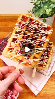 a waffle topped with chocolate and sprinkles on top of a wooden table