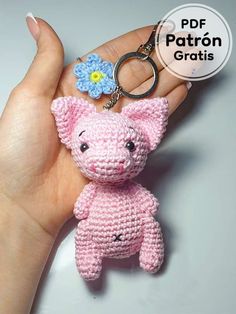 a small crocheted pig keychain with a flower on it