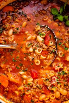 a pot filled with pasta and meat soup