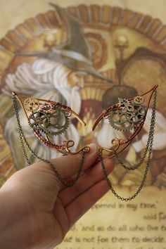 -Elf ears made with copper covered wire and metal wheels. -One size. No piercing required. -The elf ears are SOLD IN PAIRS. **USES** - Ornamentation piece; - Cosplay; - Precious gift for Steampunk and Fantasy lovers; - Great for birthdays, theme parties, Halloween, Carnival and Christmas. Each elf ear is handcrafted and there may be slight variations from the picture above. Fantasy Metal Earrings With Ear Wire, Fantasy Metal Earrings For Jewelry Making, Handmade Fantasy Metal Cartilage Earrings, Handmade Metal Fantasy Cartilage Earrings, Pierced Metal Body Jewelry For Festivals, Unique Internally Threaded Metal Earrings, Unique Nickel-free Metal Ear Cuff, Fantasy Metal Ear Cuff For Gift, Fantasy Metal Ear Cuff For Pierced Ears