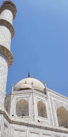 the top of a white building with arches and pillars