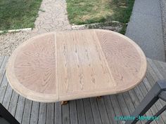 a wooden table sitting on top of a wooden deck next to a grass covered yard