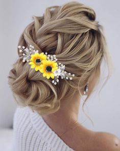 a woman with blonde hair and yellow flowers in her hair is wearing a white sweater