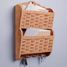 a wooden shelf with two baskets and keys hanging on the wall next to each other