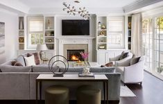 a living room filled with furniture and a fire place in the middle of a room