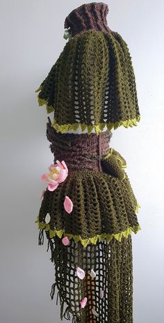 there is a crocheted dress with flowers hanging from it's back end