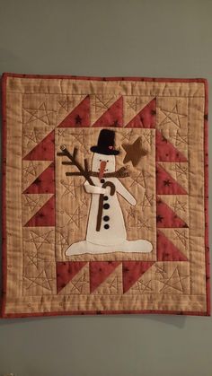 a quilted wall hanging with a snowman on it