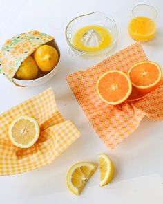 oranges, lemons, and juice are arranged on napkins to be used as garnishes