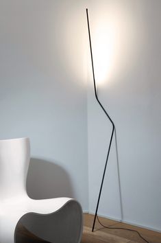 a white chair sitting next to a floor lamp