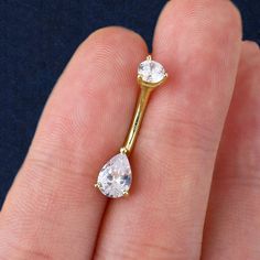 a close up of a person's hand holding a ring with two diamonds on it