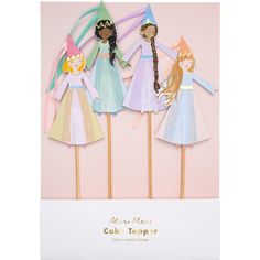 four paper dolls on top of wooden sticks in a card board box with the words meri meri cake topper