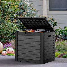 an outdoor storage box with lid open on the ground