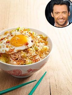 a bowl of rice with an egg on top and chopsticks next to it