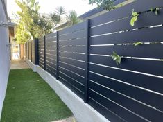 a black fence with green plants growing on it